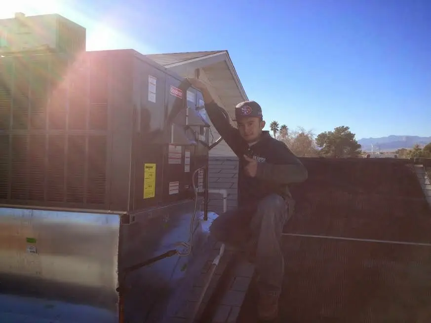 HVAC technician performing AC Tune-Up on a rooftop unit in El Cajon
